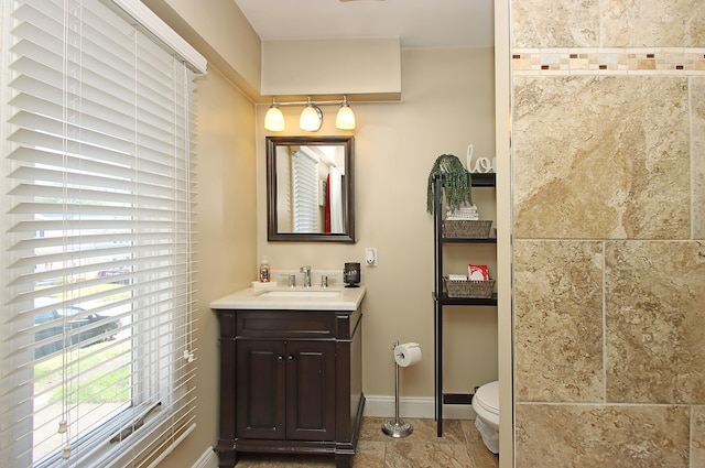 bathroom featuring baseboards, toilet, and vanity