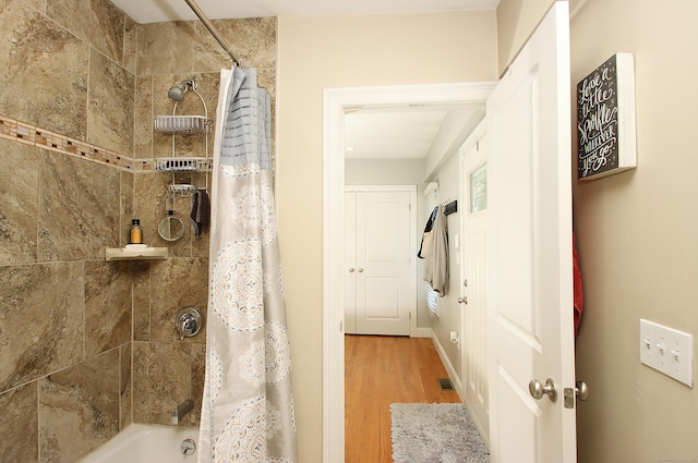 bathroom featuring visible vents, shower / bath combination with curtain, and wood finished floors