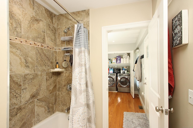 bathroom with separate washer and dryer, shower / bathtub combination with curtain, wood finished floors, and visible vents
