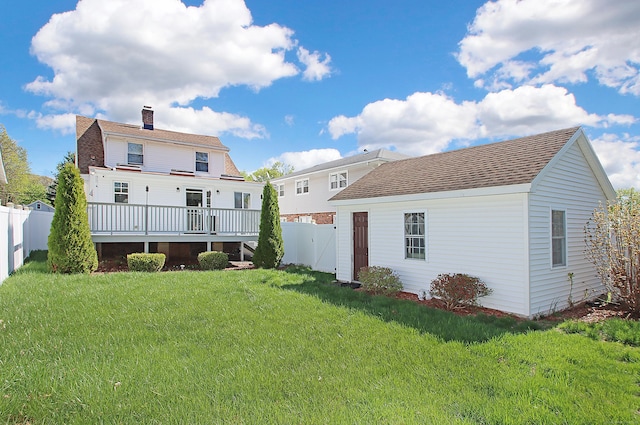 back of property featuring a fenced backyard, a wooden deck, a chimney, and a lawn