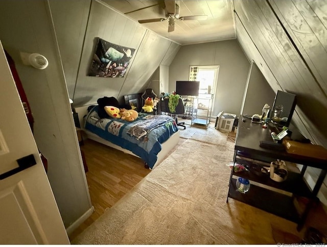 bedroom with ceiling fan, wood finished floors, and lofted ceiling