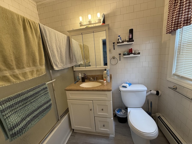 25-27 Farrows St, Putnam, CT 06260 - full bath featuring a baseboard radiator, wood finished floors, toilet, tile walls, and shower / bath combination with glass door