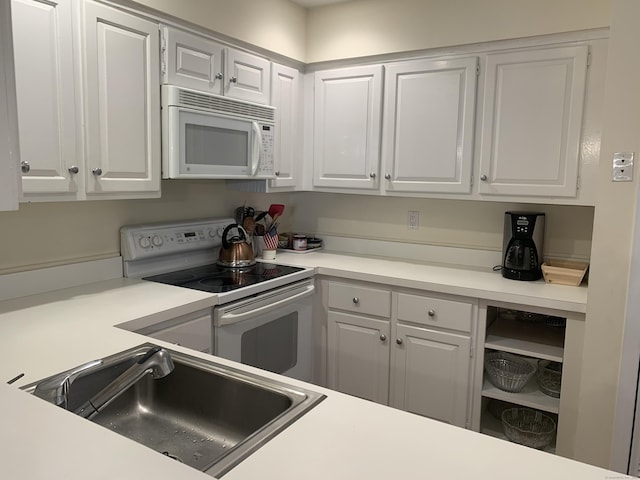kitchen with white cabinets, a sink, white appliances, and light countertops