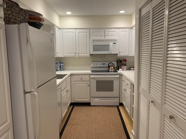 kitchen with light countertops, recessed lighting, white cabinetry, and white appliances