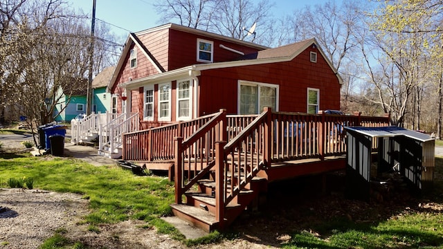 back of property featuring a wooden deck, stairway, and a gambrel roof