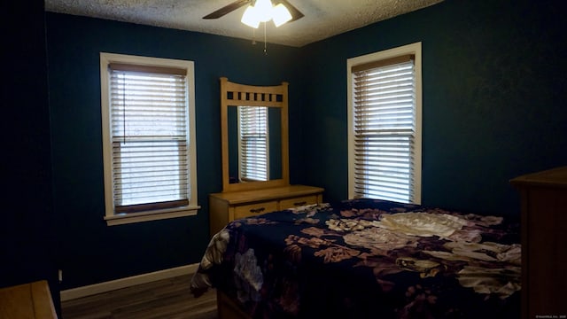 bedroom featuring wood finished floors, a textured ceiling, baseboards, and ceiling fan