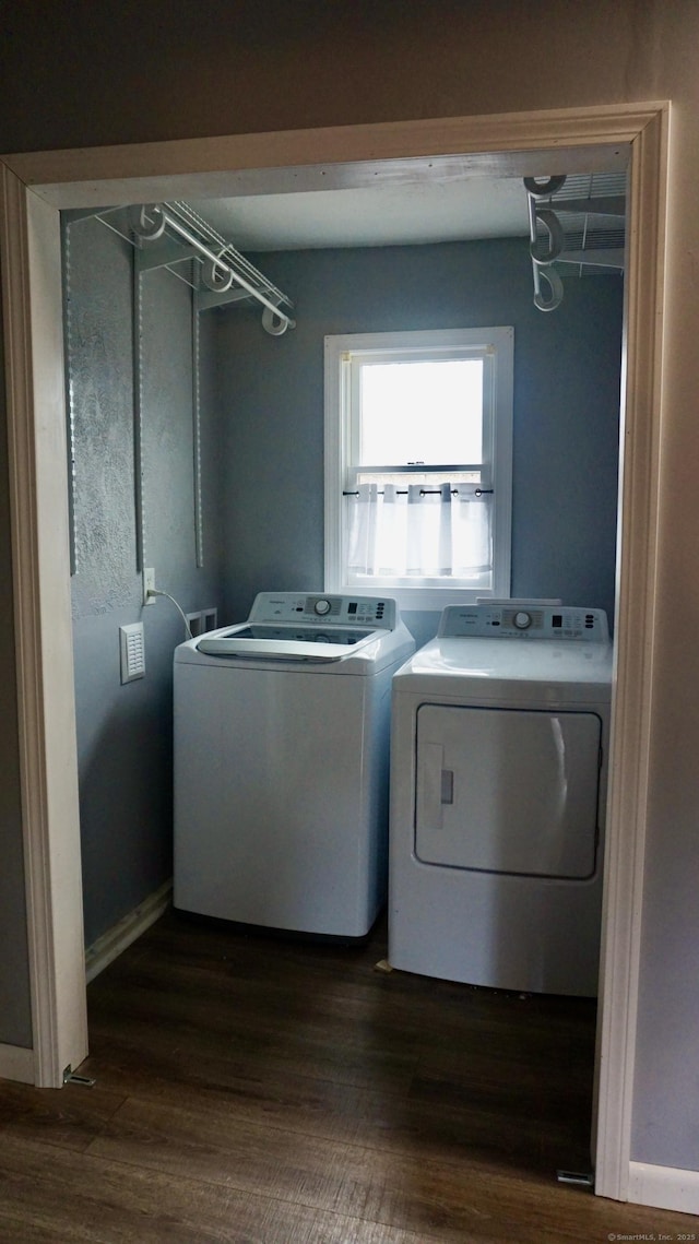 clothes washing area featuring dark wood finished floors, baseboards, laundry area, and independent washer and dryer
