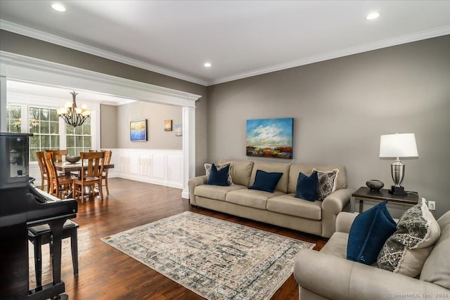 living area featuring dark wood finished floors, wainscoting, recessed lighting, a chandelier, and crown molding