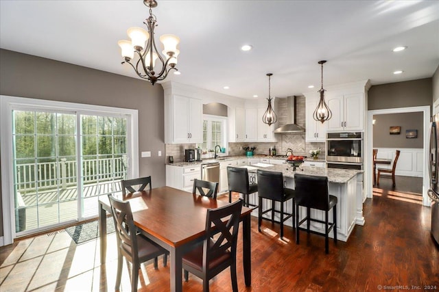 dining room with recessed lighting, dark wood-style flooring, a healthy amount of sunlight, and a notable chandelier