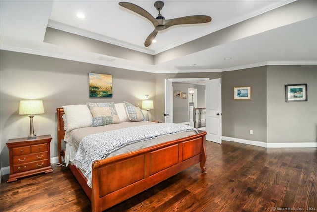bedroom featuring baseboards, crown molding, a tray ceiling, and wood finished floors