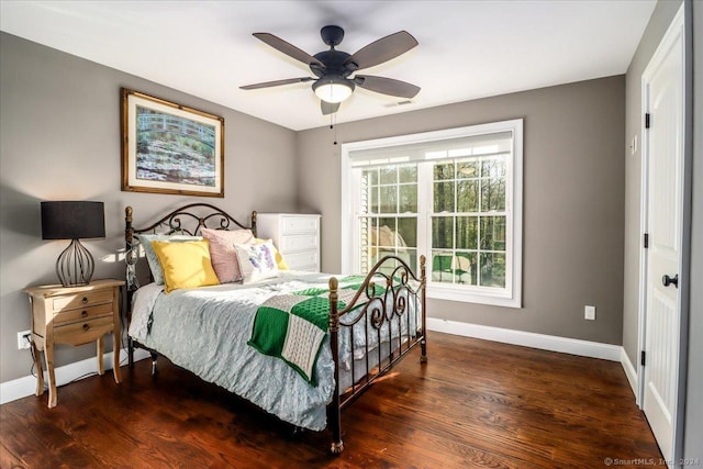 bedroom with wood finished floors, visible vents, a ceiling fan, and baseboards