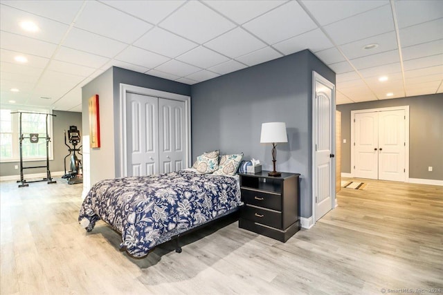 bedroom with a paneled ceiling and baseboards