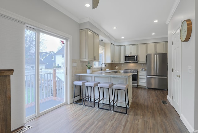 kitchen featuring a peninsula, dark wood finished floors, visible vents, light countertops, and appliances with stainless steel finishes