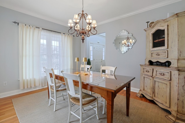 dining room featuring ornamental molding, a chandelier, and light wood-style flooring