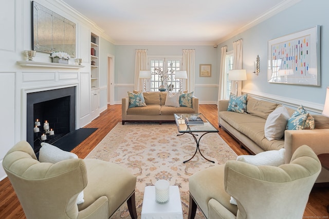 6 Wahackme Ln, New Canaan, CT 06840 - living room featuring crown molding, a fireplace with flush hearth, built in features, and wood finished floors