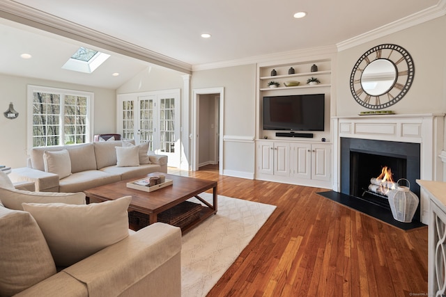 6 Wahackme Ln, New Canaan, CT 06840 - living room with vaulted ceiling with skylight, recessed lighting, a fireplace with flush hearth, wood finished floors, and ornamental molding