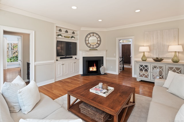 6 Wahackme Ln, New Canaan, CT 06840 - living room with a fireplace with flush hearth, crown molding, built in shelves, wood finished floors, and recessed lighting