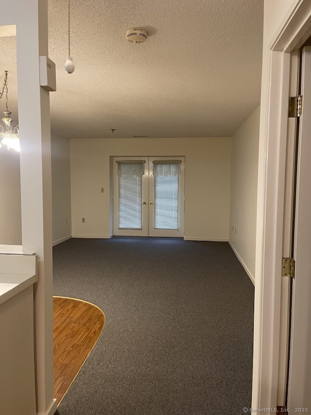 75 Washington Ave Unit 4207, Hamden, CT 06518 - spare room featuring a textured ceiling, dark colored carpet, french doors, baseboards, and a smoke detector