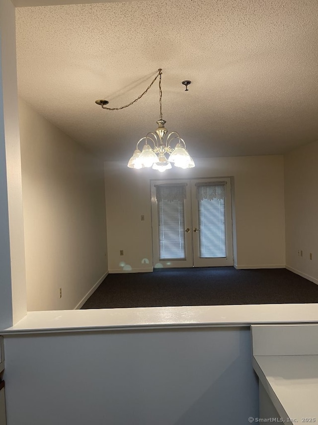 75 Washington Ave Unit 4207, Hamden, CT 06518 - spare room with a textured ceiling, french doors, a chandelier, baseboards, and carpet floors