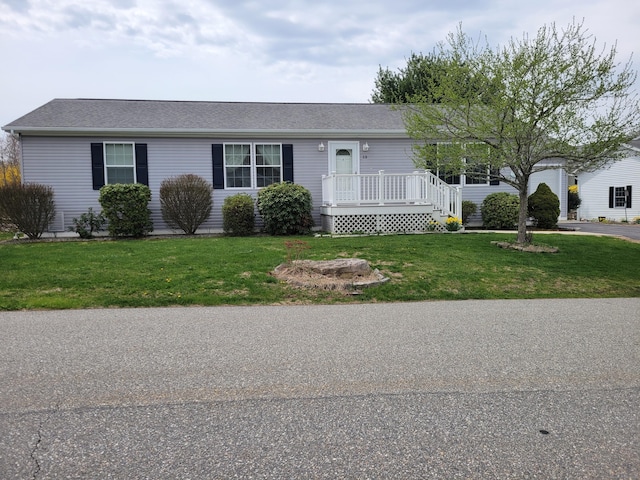 ranch-style house with roof with shingles and a front yard