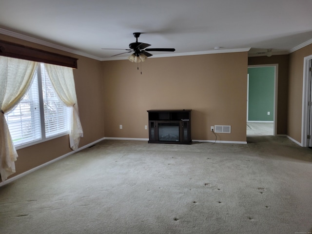 unfurnished living room with visible vents, a ceiling fan, ornamental molding, baseboards, and carpet flooring