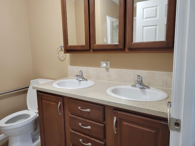full bathroom with toilet, a sink, and double vanity