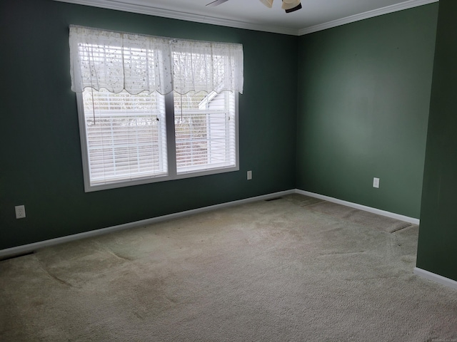 empty room with a ceiling fan, baseboards, ornamental molding, and carpet flooring