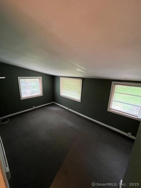 5 Stone Ct, Ledyard, CT 06335 - spare room with lofted ceiling, dark carpet, and baseboards