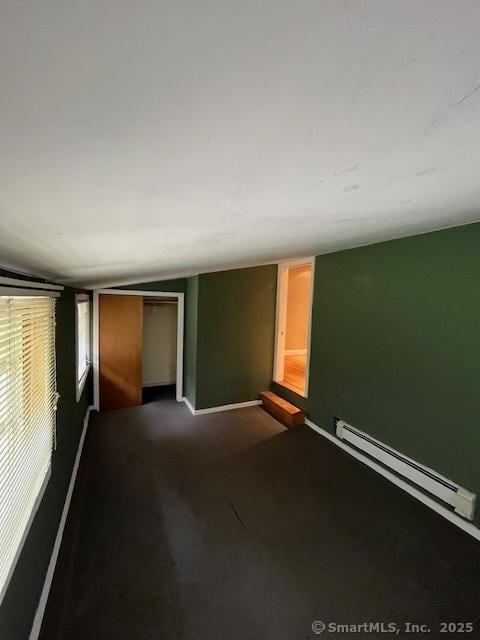 5 Stone Ct, Ledyard, CT 06335 - unfurnished room with baseboard heating, vaulted ceiling, baseboards, and dark colored carpet