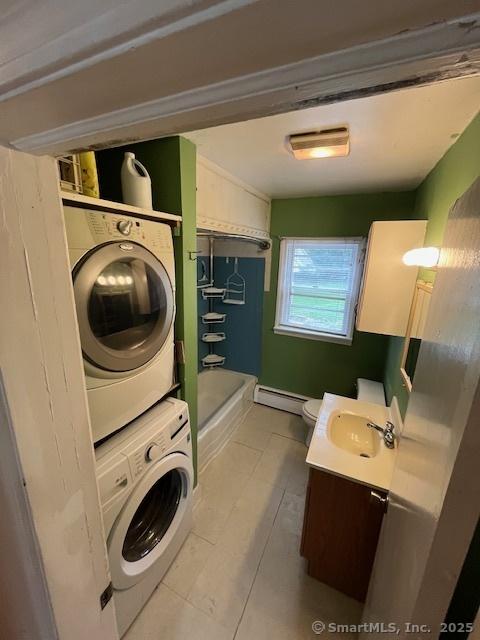 5 Stone Ct, Ledyard, CT 06335 - full bath with stacked washer / drying machine, a baseboard radiator, vanity, tile patterned flooring, and toilet