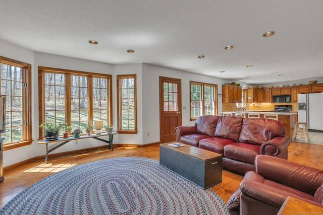 living area featuring recessed lighting, light wood-style floors, and baseboards