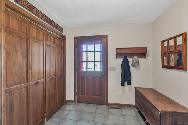 mudroom with baseboards, visible vents, and light tile patterned floors