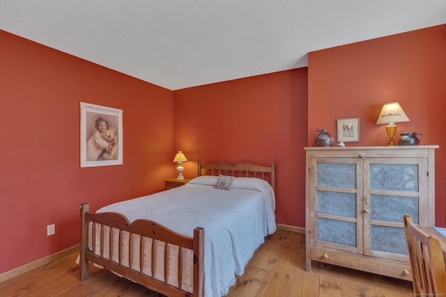 bedroom featuring baseboards and wood finished floors