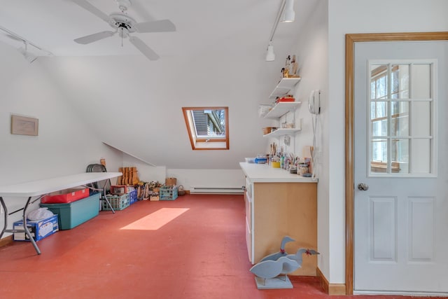 interior space featuring lofted ceiling, track lighting, a baseboard radiator, and a ceiling fan