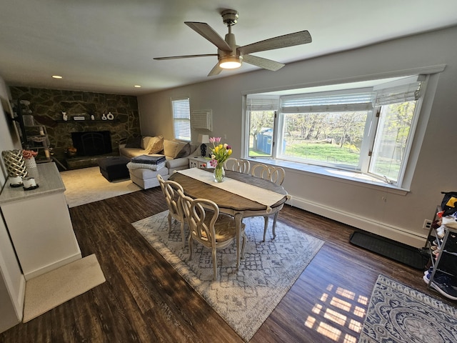 dining area featuring baseboards, recessed lighting, wood finished floors, ceiling fan, and a fireplace