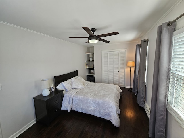 bedroom with a ceiling fan, dark wood-style flooring, crown molding, and a closet
