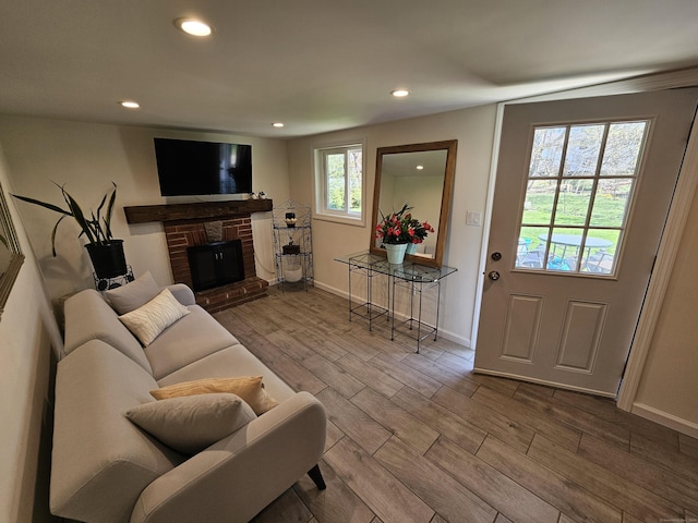 living area with baseboards, wood finished floors, and recessed lighting
