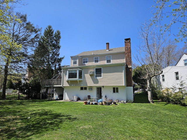 rear view of property with a chimney and a yard