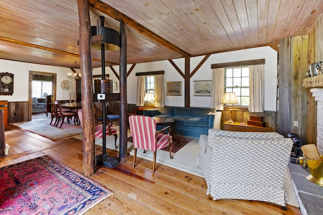 538 County Rd, Guilford, CT 06437 - living room featuring a notable chandelier, wood walls, wood ceiling, and hardwood / wood-style floors