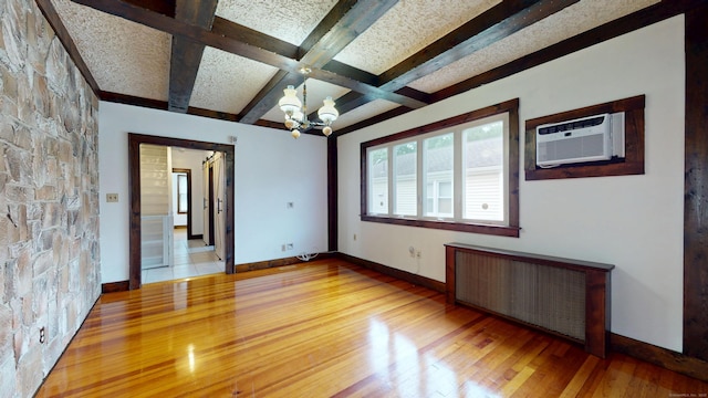 8 Kent St, Plainville, CT 06062 - empty room featuring radiator heating unit, light wood-type flooring, a chandelier, a wall unit AC, and beam ceiling