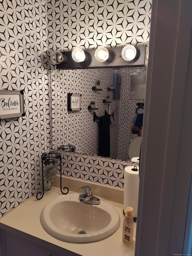 half bath featuring vanity and decorative backsplash