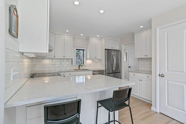 2 Donald Dr, Westport, CT 06880 - kitchen with stainless steel appliances, a sink, a peninsula, a breakfast bar area, and white cabinets