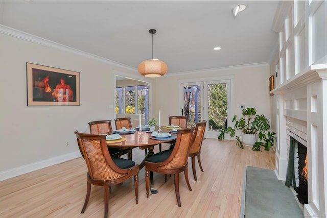 2 Donald Dr, Westport, CT 06880 - dining room with light wood-style flooring, crown molding, baseboards, a warm lit fireplace, and recessed lighting