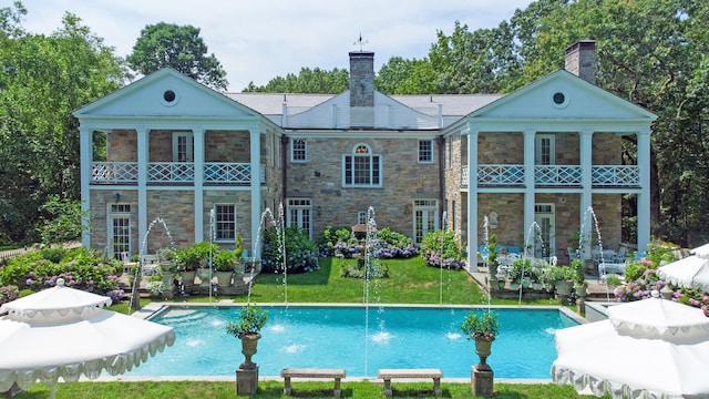 5 Northside Ln, Westport, CT 06880 - rear view of property with stone siding, a chimney, a balcony, a patio area, and a yard