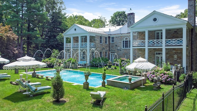 5 Northside Ln, Westport, CT 06880 - back of property featuring stone siding, a balcony, a chimney, and a pool with connected hot tub