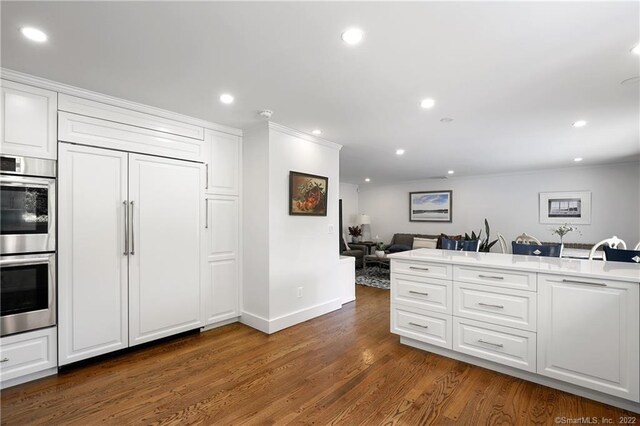 41 Hermit Ln, Westport, CT 06880 - kitchen with white cabinets, dark wood-style flooring, and stainless steel double oven