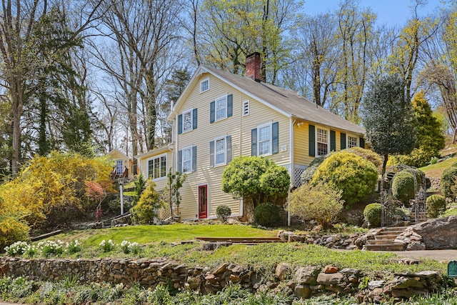 view of front of house with a front yard and a chimney