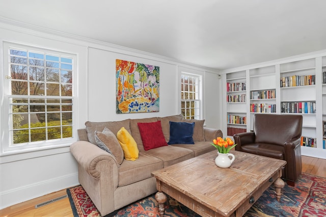living room featuring visible vents, a wealth of natural light, and wood finished floors