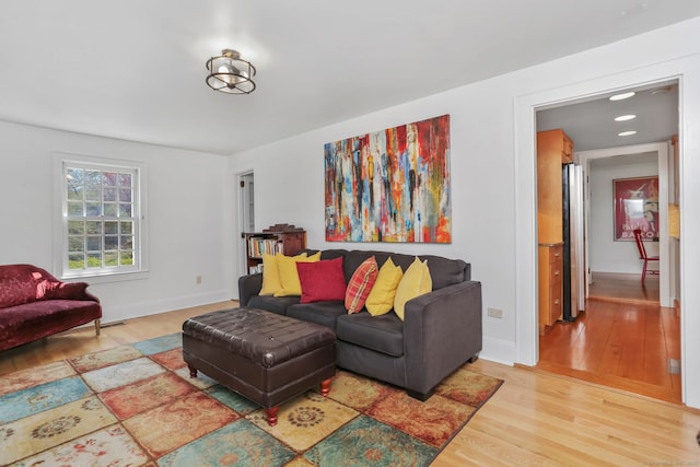 living area featuring baseboards and light wood-style flooring