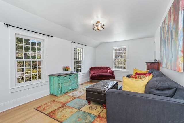 living room featuring baseboards, wood finished floors, and lofted ceiling